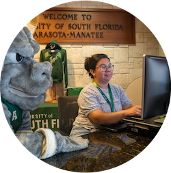 Front Desk employee on computer at Sarasota Campus