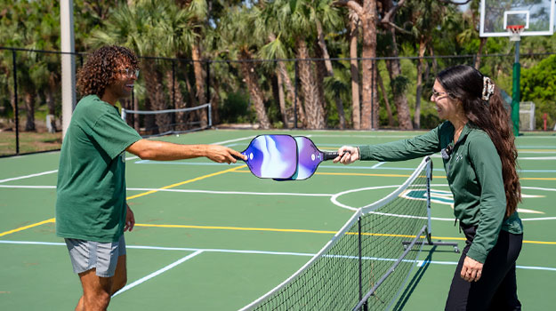 Students playing pickleball on outdoor courts