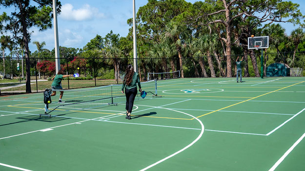 Students playing pickleball and basketball on outdoor courts