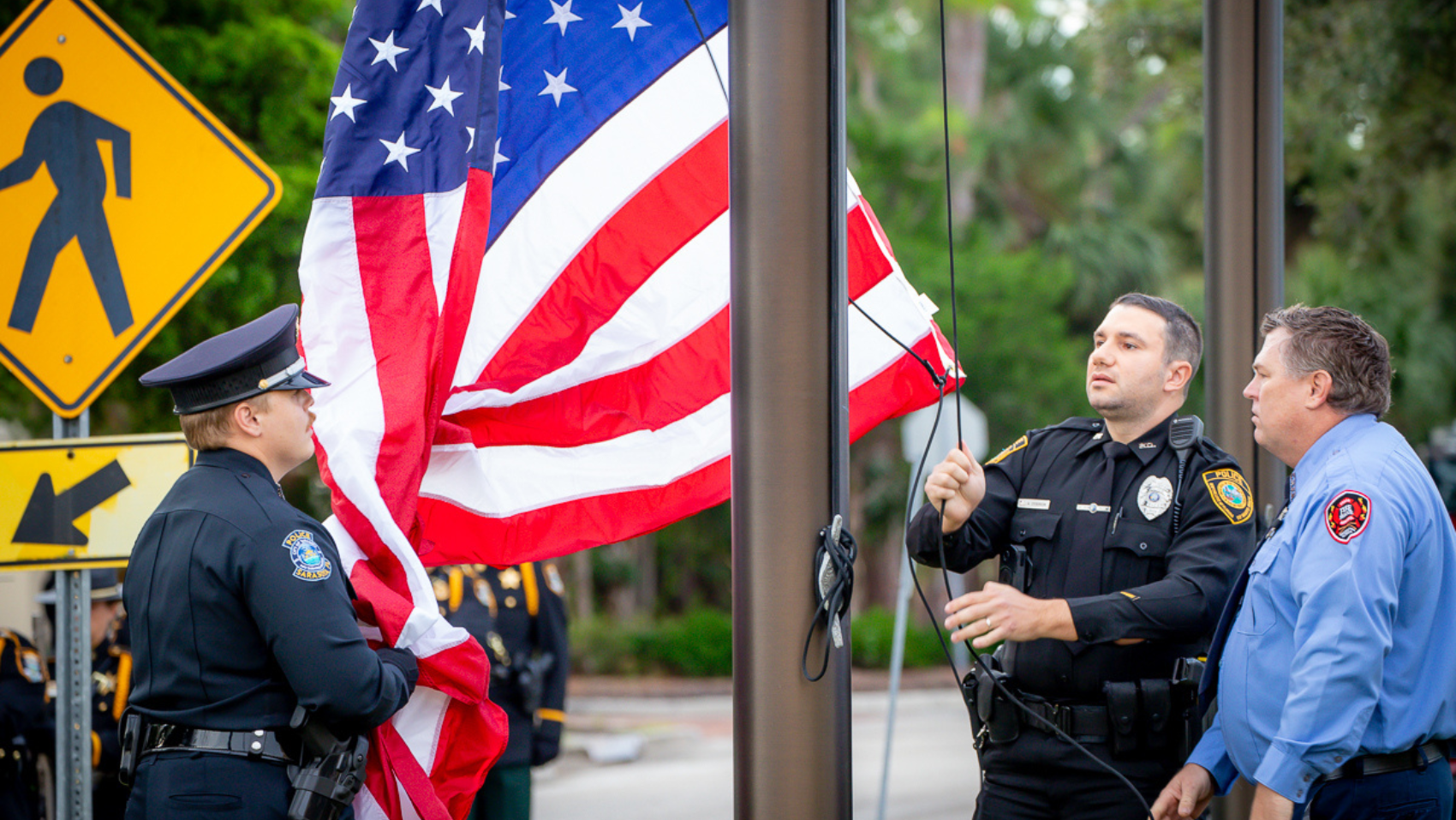 Law enforcement officers and a firefighter raise the American flag during the September 11 remembrance ceremony at the University of South Florida Sarasota-Manatee campus.