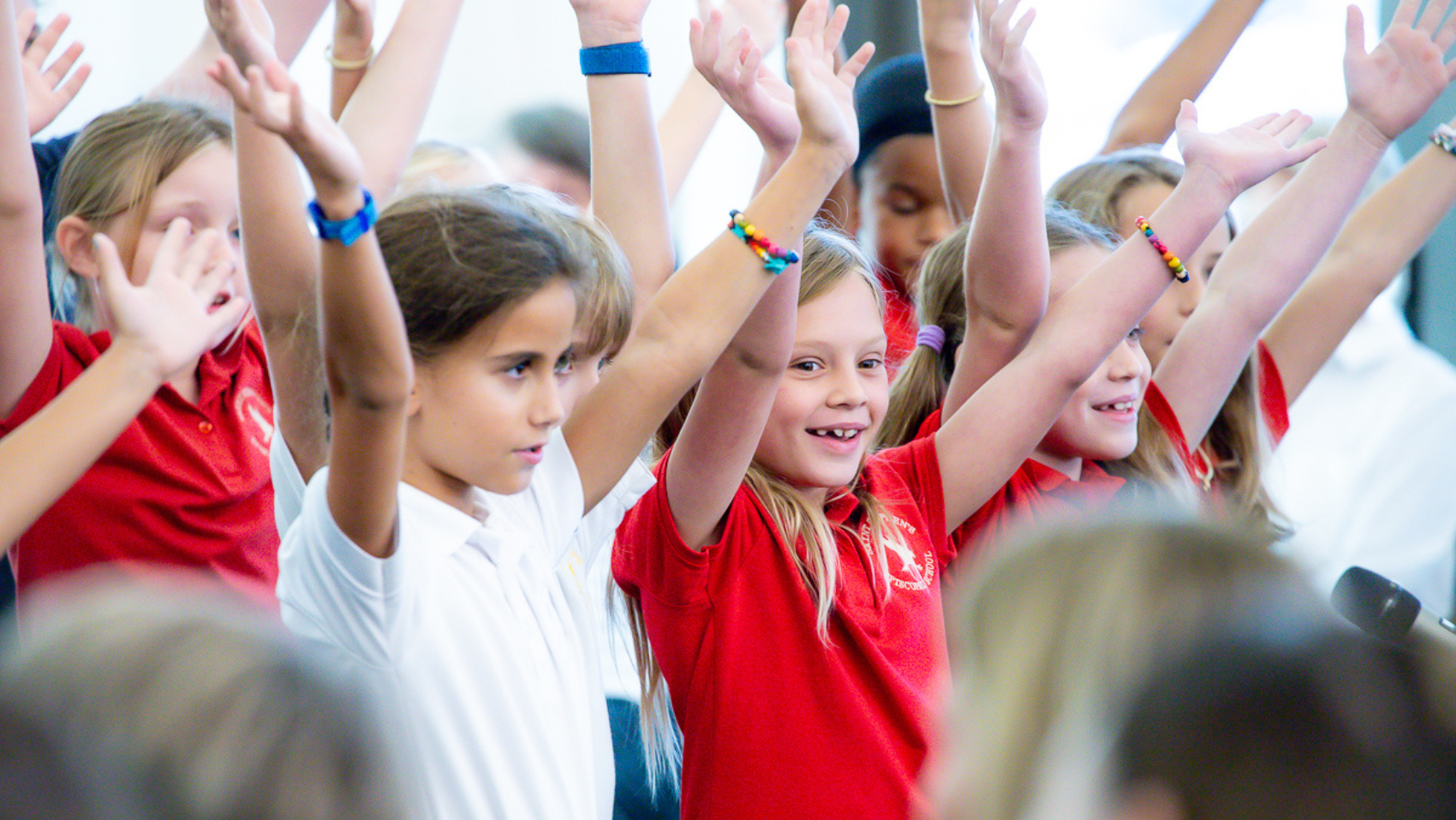 Elementary school students raise their arms while singing during the September 11 remembrance ceremony at the USF Sarasota-Manatee campus.