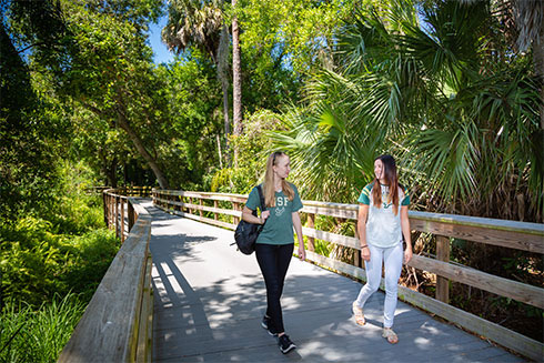 Two USF students walking on a bridge.