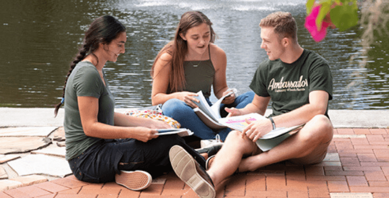 Students sit together by the water