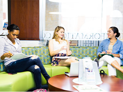 Three USF students waiting outside an office.