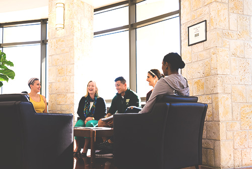 a group of people talking and sitting in the building lobby