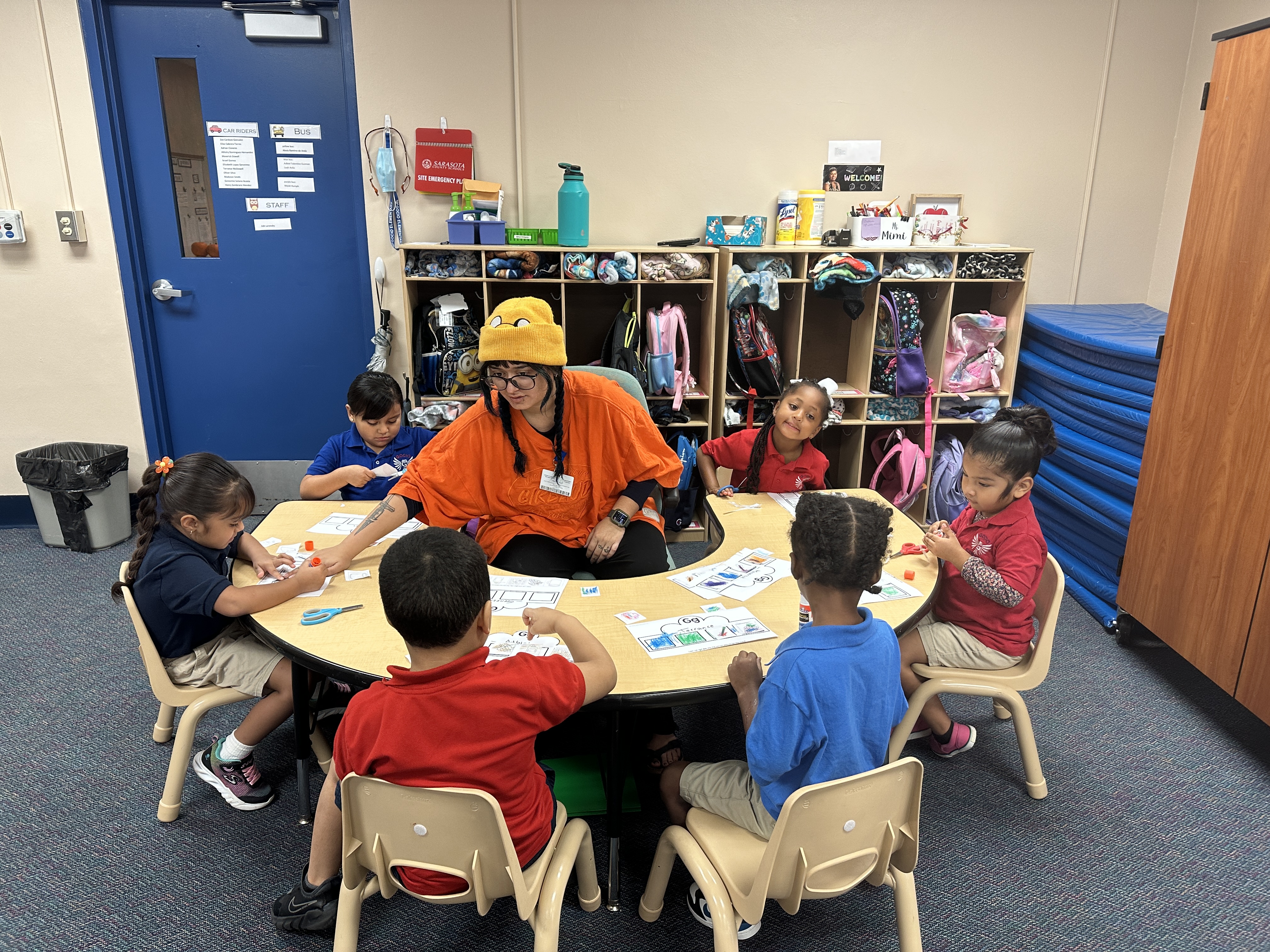 Nicolle gets hands-on experience in Pre-K students around a table.