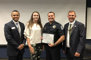 Carlos Moreira, Paige Morrison and Jay Riley, right, present a Certificate of Appreciation to Sarasota Police Department Dep. Chief Pat Robinson.