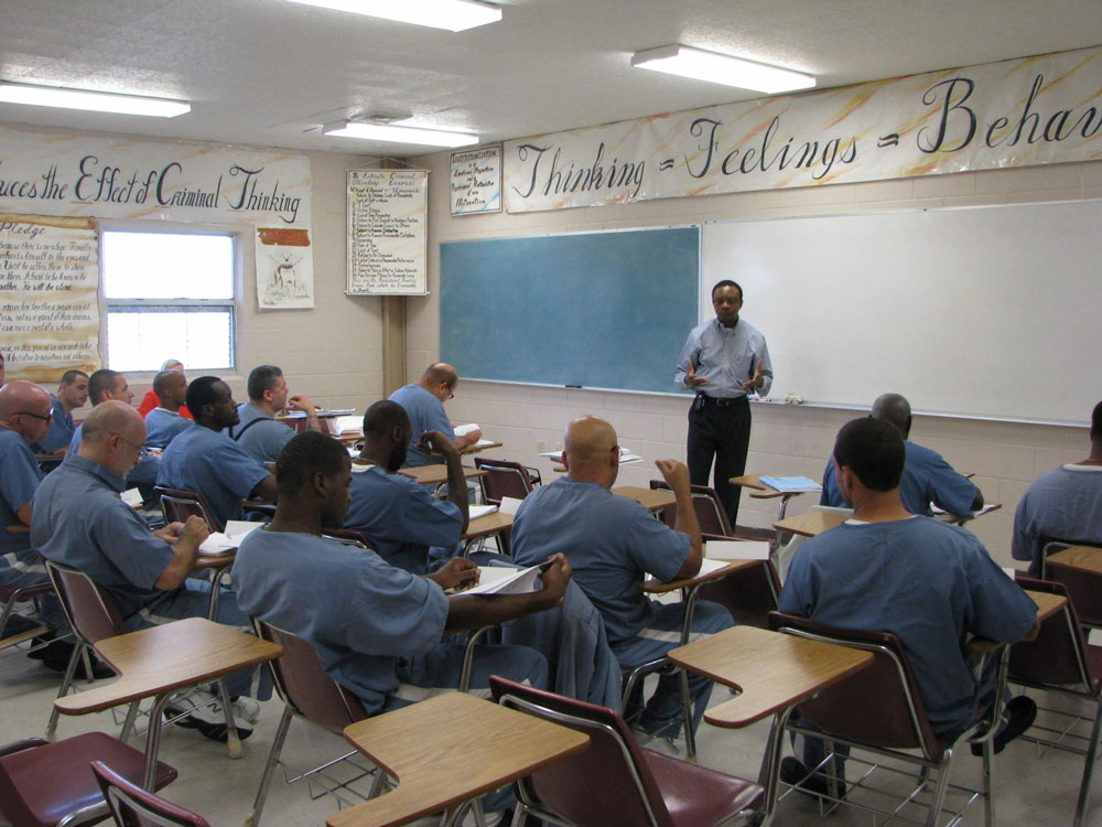 Dr. Jean Kabongo instructing prisoners in a jail classroom.