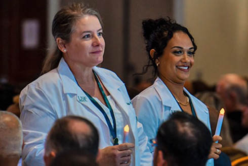 USF Nursing graduates lead the Path of Light procession following Summer Pinning 2023