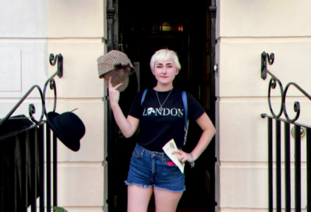 elyssa posing in front of a door wearing a shirt with the name London