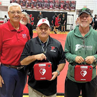 Ernie Withers, left, poses with Palmetto High School staff members after donating two automated external defibrillators (AEDs) to the Bradenton school.
