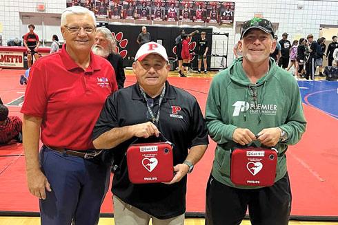Ernie Withers, left, poses with Palmetto High School staff members after donating two automated external defibrillators (AEDs) to the Bradenton school.