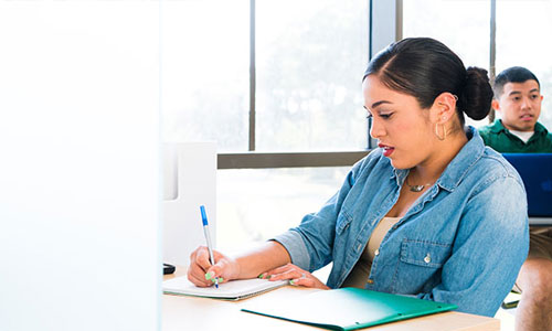 female student writing in notepad